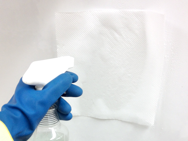 床と壁全体にキッチンペーパーを当てて、重層水をスプレーします