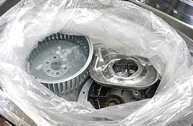 ゴミ袋にお湯と換気扇のパーツを入れる