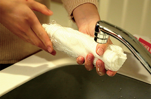 ① 水で濡らしたタオルにアルカリ電解水を15回程度吹きかける。② 軽くもみ込んで、馴染ませてからタオルをラップで包む。