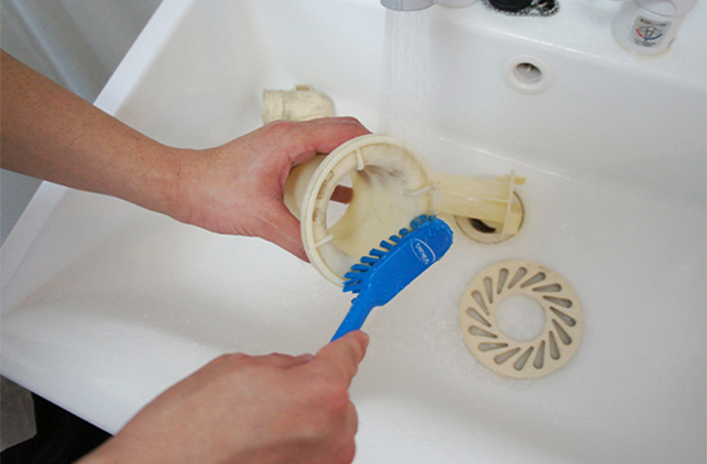 排水口の部品を外し、浴室用洗剤とブラシで洗う